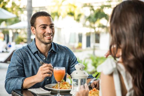 a man sitting at a table with a woman eating food at Solace by the Sea in Ponce