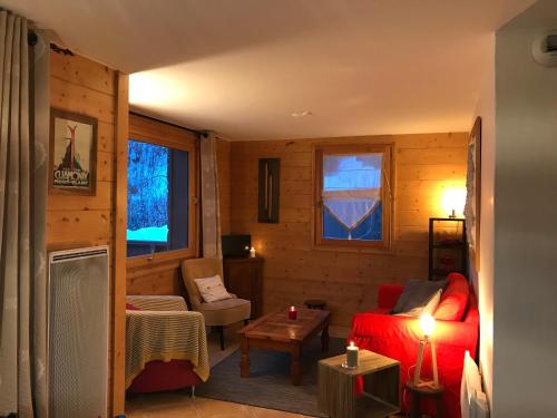 un salon avec un canapé rouge et une table dans l'établissement Kandahar, aux Houches