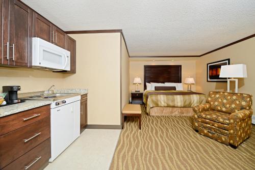 a hotel room with a bed and a kitchen at Siding 16 Lodge in Wetaskiwin