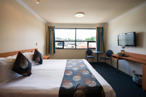 Habitación de hotel con cama grande y TV en Black Buffalo en Hobart