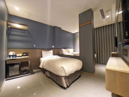 a hotel room with a bed and a television at Beauty Hotels Taipei - B7 Journey in Taipei