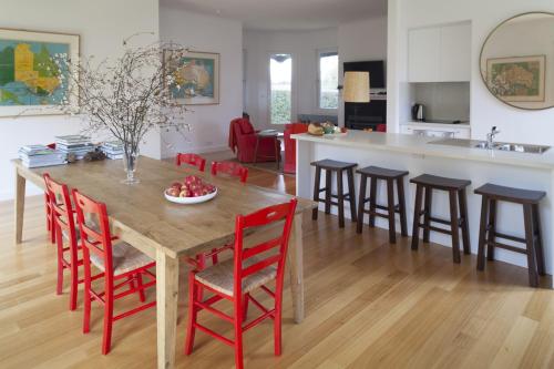 
a kitchen with a table, chairs, and a table cloth at The Cottage at Bolobek in Macedon
