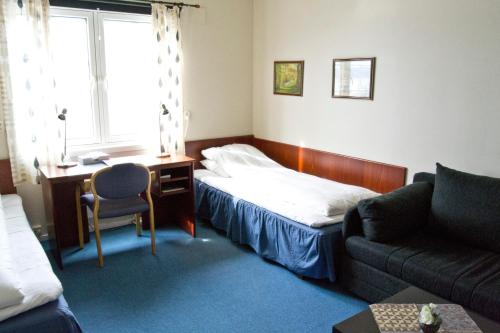 a bedroom with a bed and a desk and a couch at Moi Hotel in Moi