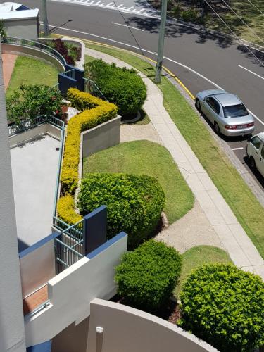 a car parked on a street next to a building at Excellsior Apartments in Mooloolaba
