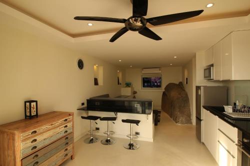 a kitchen with a ceiling fan and bar stools at Baan Seaview Holiday Villas in Lamai
