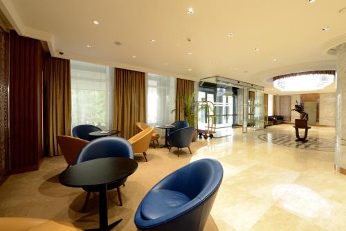 a lobby with blue chairs and tables in a building at Kempinski Hotel Khan Palace in Ulaanbaatar