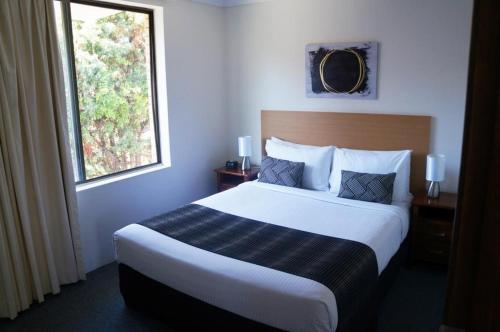 a hotel room with a large bed with a window at Jadon Place Holiday Apartments in Gold Coast