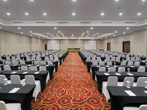 a large room with chairs and tables in it at d'primahotel Kualanamu Airport Medan in Medan