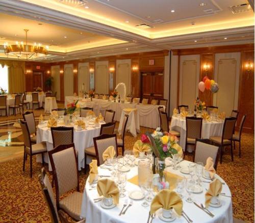 a banquet hall with tables and chairs with white tablecloths at Norwalk Inn & Conference Center in Norwalk