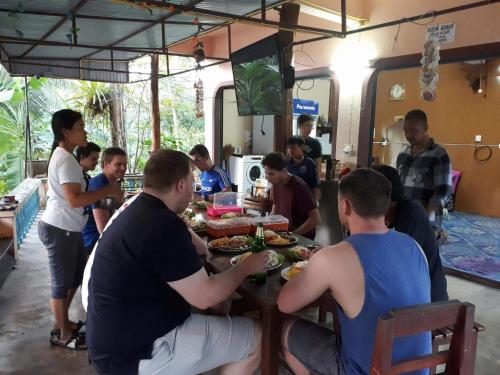 a group of people sitting at a table eating food at Baan Klong House in Baan Khai