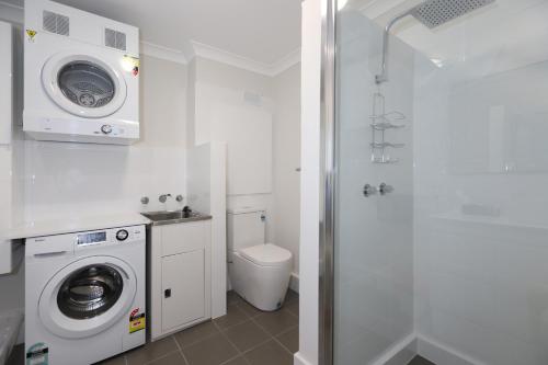 a bathroom with a washing machine and a toilet at West Beach Lagoon 218 - Outstanding Value! in Perth