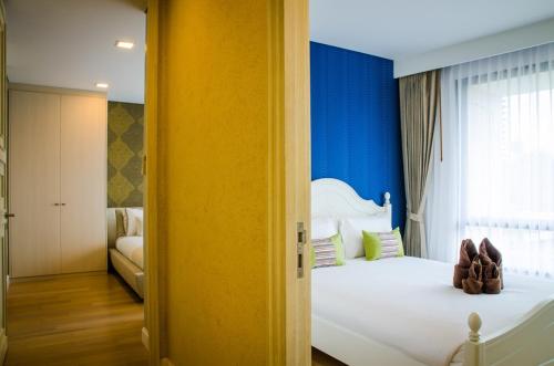 - une chambre avec un lit blanc aux murs bleus dans l'établissement Marakesh Hua Hin Resident-Room Type E, à Hua Hin