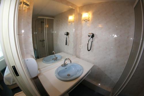 a bathroom with a sink and a phone on the wall at Hôtel Saint-Marc in Ploërmel