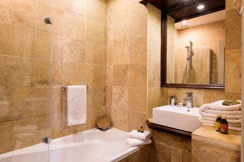 La salle de bains est pourvue d'une baignoire, d'un lavabo et d'un miroir. dans l'établissement Heart of Sarlat, à Sarlat-la-Canéda