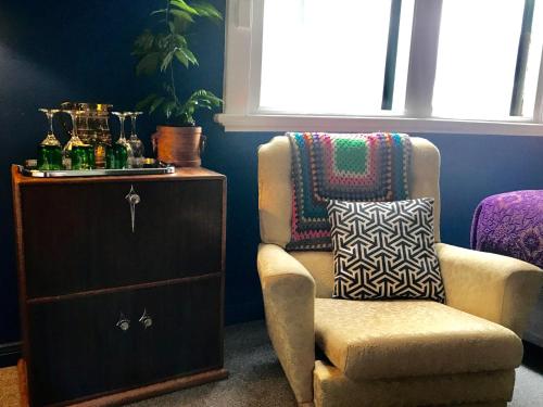 a living room with a chair and a dresser at Vine Valley Inn in Cessnock