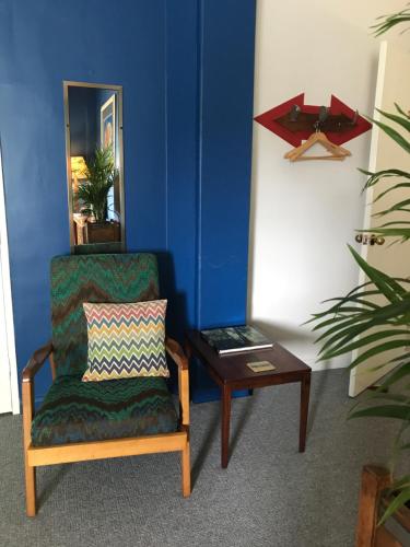 a living room with a chair and a table at Vine Valley Inn in Cessnock