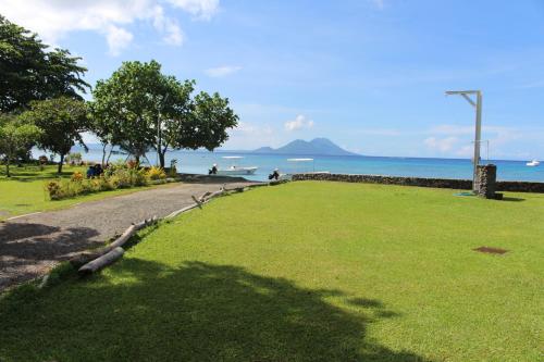 a park with a grass field and the ocean at Rapopo Plantation Resort in Kokopo