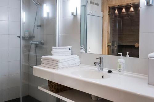 a white bathroom with a sink and a shower at Vuokatti Sport Chalets in Vuokatti