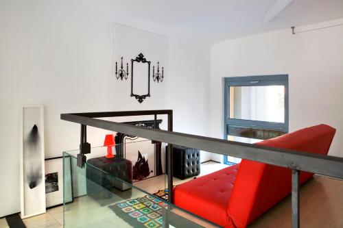 ミラノにあるRosso Segnale Milanoの赤いソファとガラスの床が備わるリビングルーム