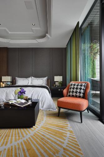 a bedroom with a bed and a chair and a table at Ease Motel Taichung in Taichung