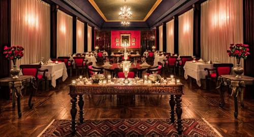 a large dining room with tables and red chairs at Suryagarh Jaisalmer in Jaisalmer