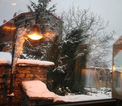 a street light covered in snow next to a fountain at Grand House Suites in Palaios Agios Athanasios