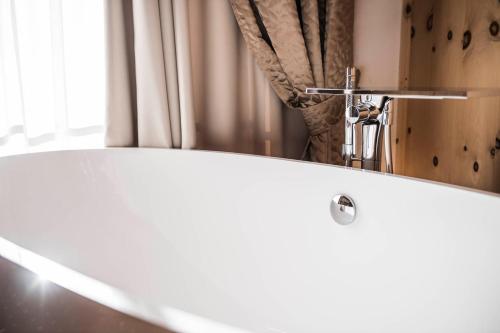 a bathroom with a white sink and a mirror at Alpin Garden Luxury Maison & SPA - Adults Only in Ortisei