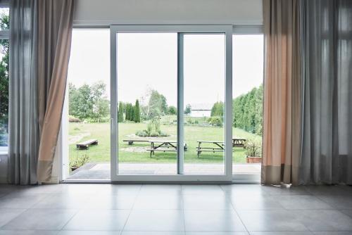 an open glass door with a view of a park at Zajazd Podzamcze in Fałków
