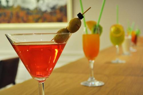 a drink with olives on top of a wooden table at Pera Tulip Hotel & Spa - Istanbul Taksim Pera City Center in Istanbul