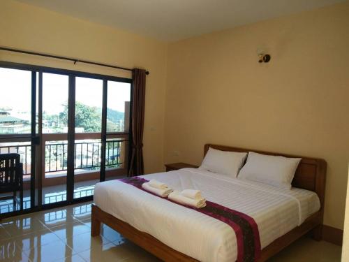 um quarto com uma cama com duas toalhas em Hill Top Home em Santikhiri