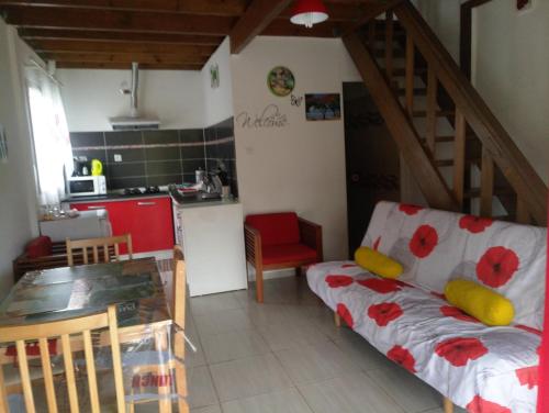 ein Wohnzimmer mit einem Sofa und einer Küche in der Unterkunft Les Jardins Créoles in Cilaos