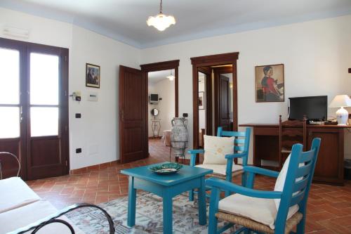 a living room with blue chairs and a table at Hotel Resort Nuraghe Arvu in Cala Gonone