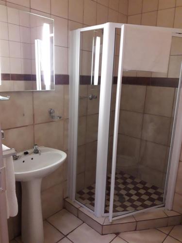 a bathroom with a shower and a sink at Airport Hotel in Kimberley