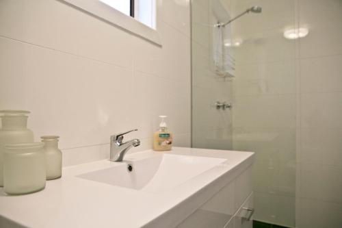 a white bathroom with a sink and a shower at Breakaway Views 374 ALP ST in Coober Pedy