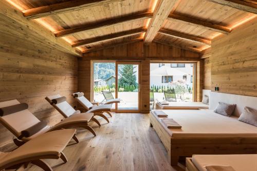 een kamer met stoelen, een bed en ramen bij Pepi's Suites - Lechtal Apartments in Holzgau