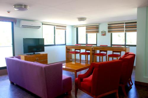 a room with a bar with red chairs and a table at Saipan Beach Hotel in Saipan