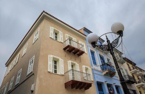 a tall building with white windows and a street light at Amymone Suites in Nafplio