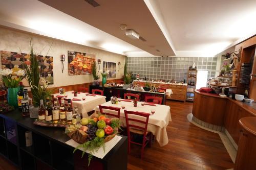 キアッソにあるホテル バーンホフ ハウスのテーブル2台と食べ物カウンター付きのレストラン