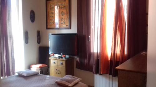 een slaapkamer met een televisie en een kleine dressoir met een bed bij Villa la clémente in Menton