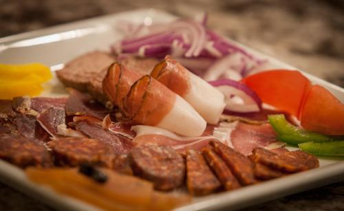 a plate of food with meat and vegetables on a table at Anna Hotel in Budapest