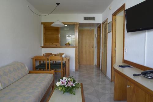 a living room with a couch and a table at TRH Jardín Del Mar in Santa Ponsa