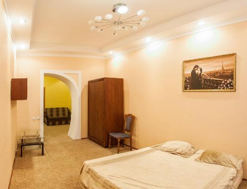 リヴィウにあるКвартира подобово на вулиці Кониського 5, 2кім біля Медичного університетуのベッドルーム1室(ベッド1台付)が備わります。壁には絵画が飾られています。