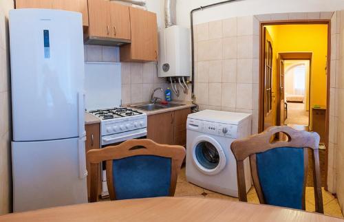 eine Küche mit einem Kühlschrank und einer Waschmaschine in der Unterkunft Квартира подобово на вулиці Кониського 5, 2кім біля Медичного університету in Lwiw