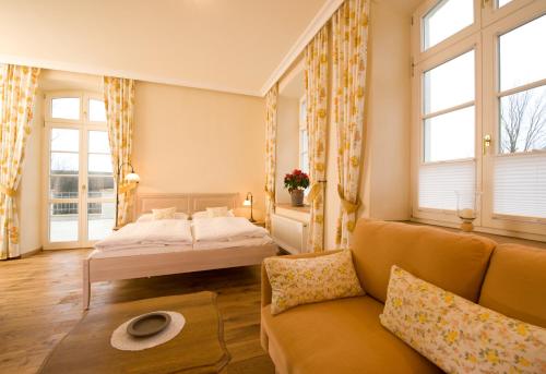 a living room with a bed and a couch at Hotel Gutshaus Parin - Bio- und Gesundheitshotel in Parin