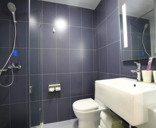 
a bathroom with a shower, toilet and sink at Hanting Hotel Beijing Qianmen in Beijing
