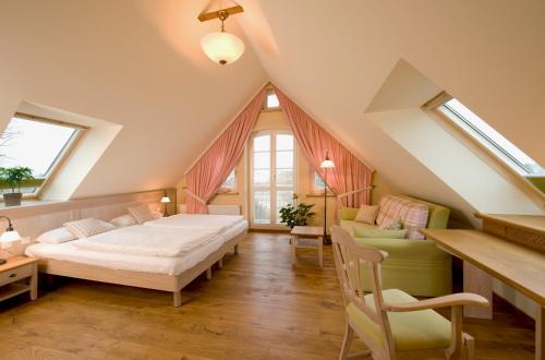 a attic bedroom with two beds and a couch at Hotel Gutshaus Parin - Bio- und Gesundheitshotel in Parin