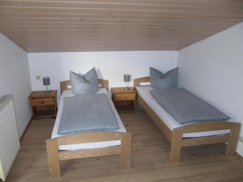 a bedroom with two beds and two night stands at Buchenweg 40a in Isenbüttel