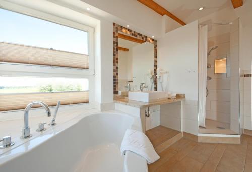 Parin的住宿－古斯帕林生態格桑酒店，带浴缸、水槽和窗户的浴室