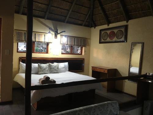 a bedroom with a bed with a teddy bear on it at Mabalingwe Elephant Lodge in Bela-Bela