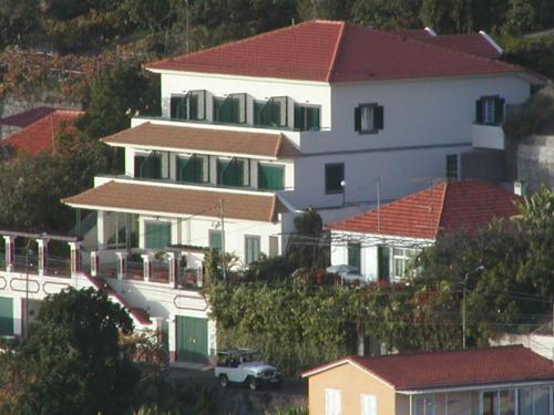 a large white house with red roofs on a hill at Vila Marta in Funchal